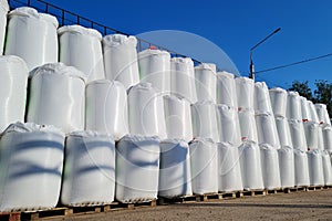 Group of white big bags with chemical fertilizers in a warehouse outdoors