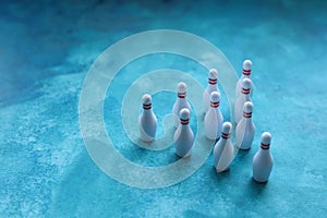 Group of white bowling pins on a blue background. Selective focus.