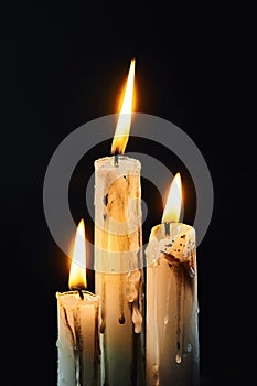 Group of white candles burning in the dark