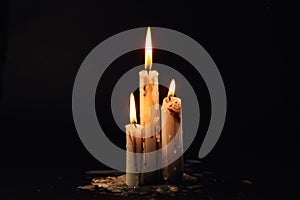 Group of white candles burning in the dark