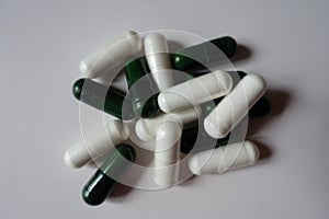 Group of white capsules of magnesium citrate and green capsules of multivatamins