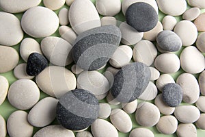 Group of white and grey pebbles in two layers, simple stones background