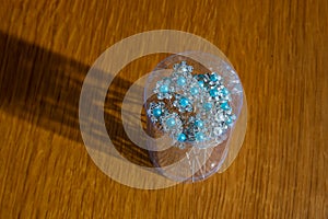 Group of white metal hairpins with beaded flowers in can on the table