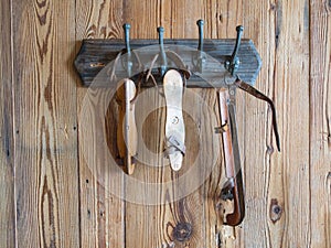 Group of white old ice skates hanging on a wooden wall