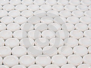 Group of white round pills on a blue background.