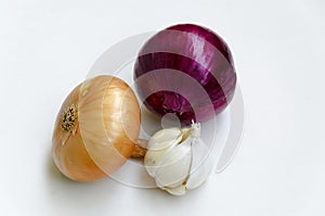 Group of whole ripe yellow onion, red onion and garlic on a white background