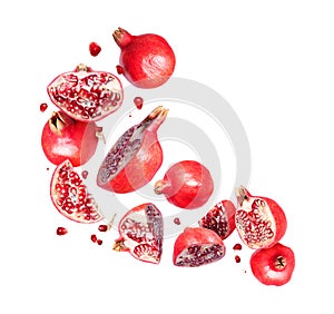 Group of whole and sliced pomegranates in the air isolated on a white background