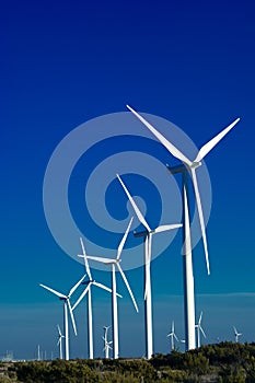 A group of wind turbines with blue sky background
