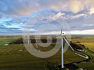 a group of wind turbines in a field under a cloudy sky