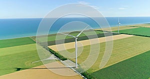 Group of windmills for electric power production in the agricultural fields. Aerial view