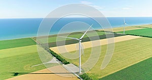 Group of windmills for electric power production in the agricultural fields. Aerial view