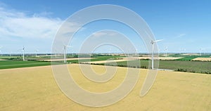 Group of windmills for electric power production in the agricultural fields. Aerial view.