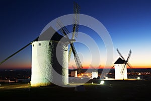 Group of windmills at field in evening.