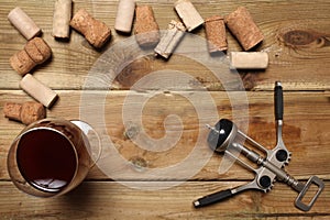 Group of wine bottle cork, a glass of red wine and a corkscrew on a wooden table with copy space for your text