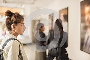 Group of woman looking at modern painting in art gallery