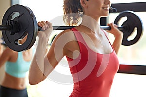 Group of women with barbells working out in gym