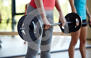 Group of women with barbells working out in gym