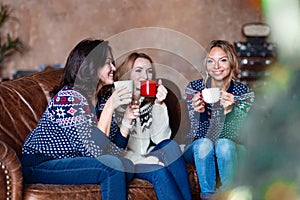 Group of women chatting while drinking coffee at modern loft