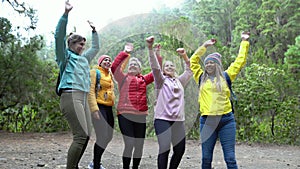 Group of women with different ages and ethnicities having a funny moment dancing during a walk woods