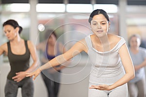 Group of women of different ages are learning various dance and ballet movements in studio