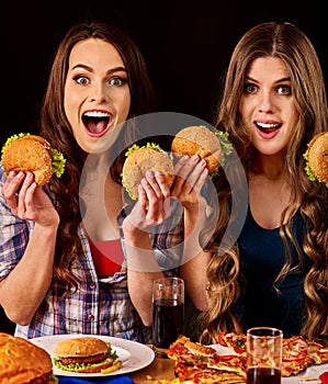 Group women eat best hamburger and pizza in burger bar