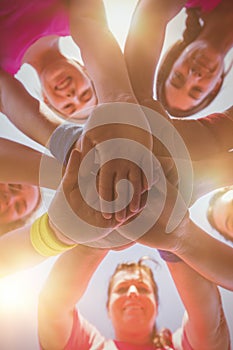 Group of women forming hand stack in the boot camp