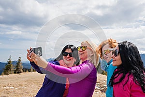 Group of women make self portraits during a mountain hike on top