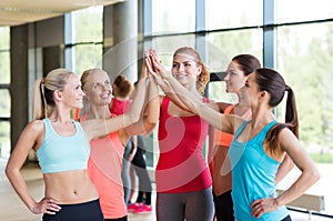 Group of women making high five gesture in gym