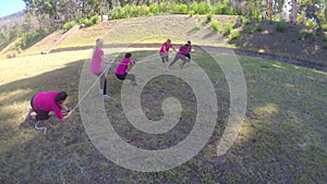 Group of women playing tug of war during obstacle course training 4k