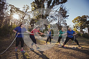 Group of women playing tug of war during obstacle course training