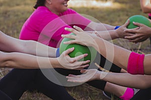 Group of women practicing ball sit up exercise in the boot camp photo