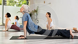 Group of women practicing yoga training - pose bhujangasana