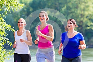 Group of women running at lakeside jogging