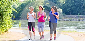 Group of women running at lakeside jogging