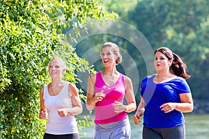 Group of women running at lakeside jogging