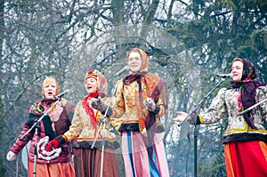 The group of women sing a song, on Maslenitsa, in traditional Russian clothers in Moscow.