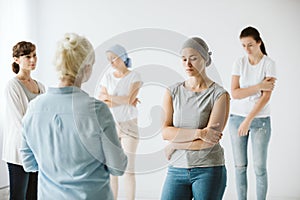 Group of women talking together during psychotherapy with senior counselor