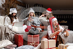 Group of women wearing Christmas hats make greeting video calls at Christmas time