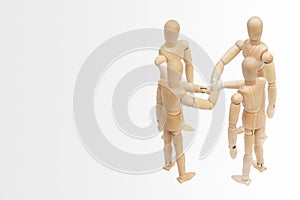 Group of wooden figure mannequin putting stack their hands together.