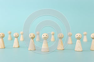 Group of wooden figures with smiling faces. Concept of satisfaction and happiness