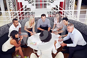 Group of work colleagues having meeting in an office lobby