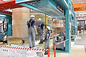 Group worker assembles a transformer in mechanical engineering - photo