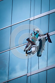 Group of workers cleaning windows service on high rise building