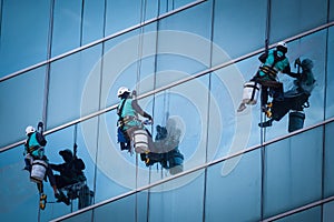 Group of workers cleaning windows service on high rise building