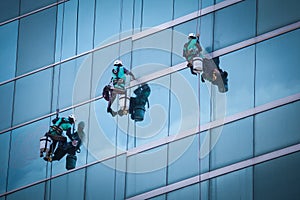 Group of workers cleaning windows service on high rise building