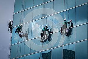 Group of workers cleaning windows service on high rise building