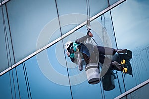 Group of workers cleaning windows service on high rise building