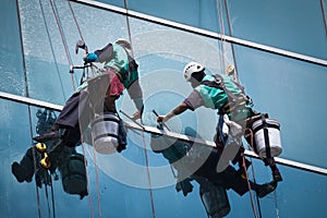 Group of workers cleaning windows service on high rise building