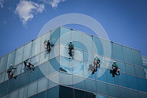 Group of workers cleaning windows service on high rise building