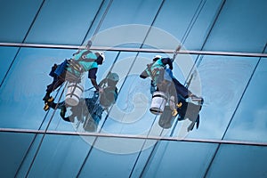 Group of workers cleaning windows service on high rise building photo